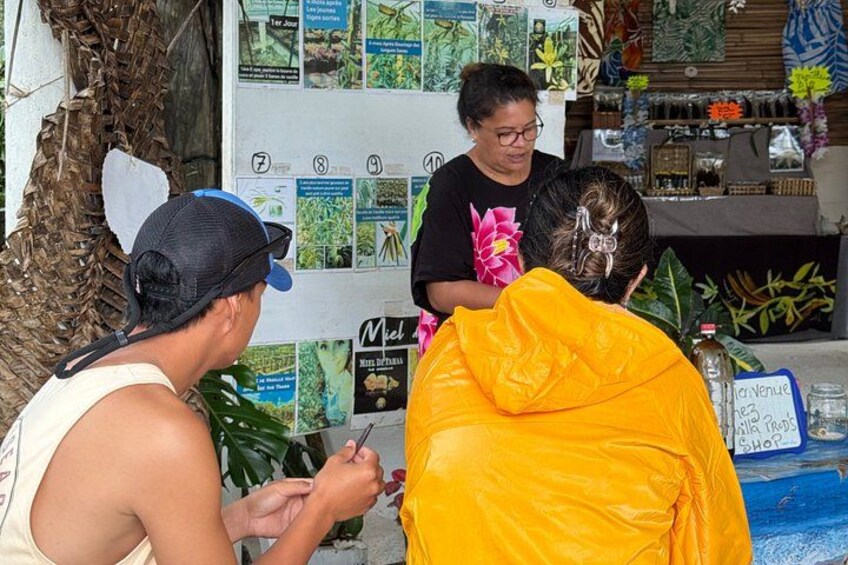 A person in a yellow jacket, another in a black shirt, and a third in a white tank top, engaged in a discussion. 3