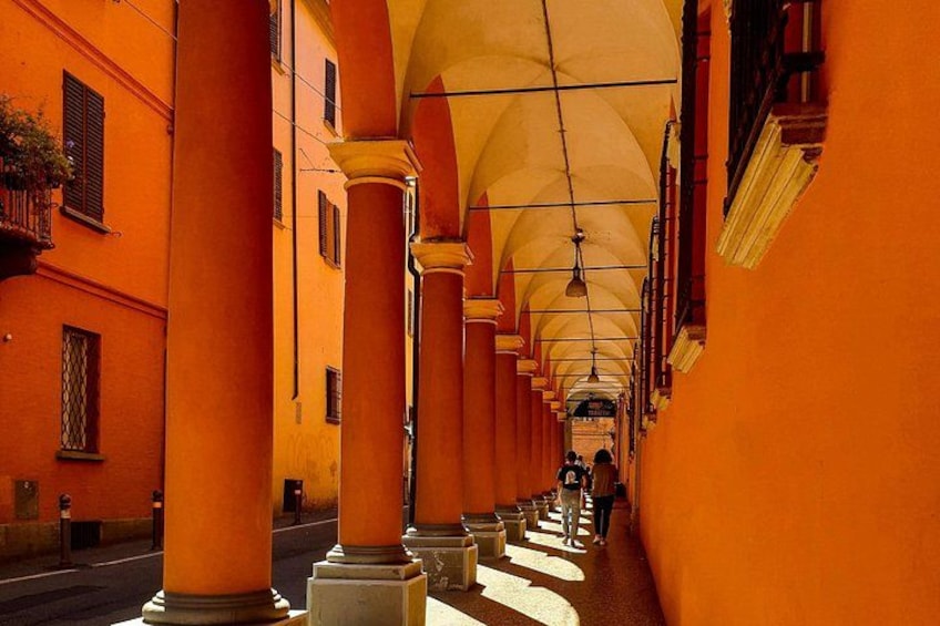 A corridor with orange walls and columns, leading to a distant point. 2