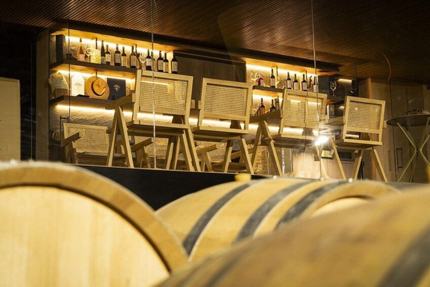 Wooden barrels, a bar area with bottles, and a rustic interior. 2