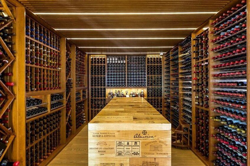 A wine cellar with wooden racks and a central wooden table. 4