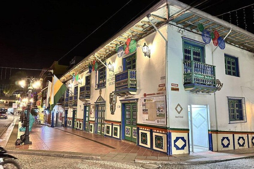 A brightly lit street with colorful buildings, a red door, and decorative elements. 3