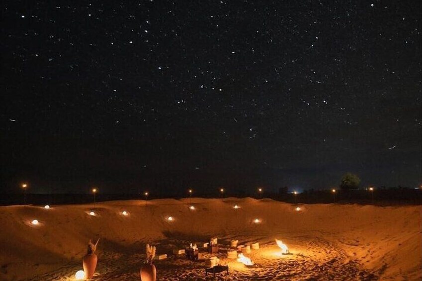 A starry night sky, a desert landscape, and a campfire. 3