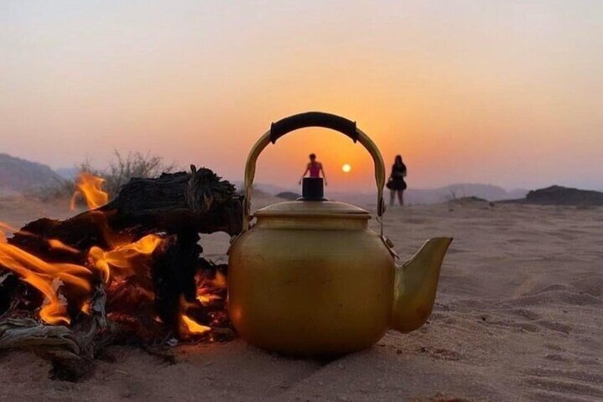 A yellow kettle on a desert fire with a sunset in the background. 2