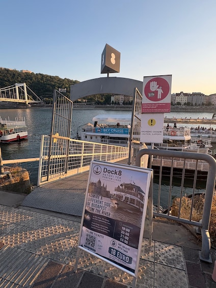 A dock with a sign for Dock8, a bridge, and a boat. 4