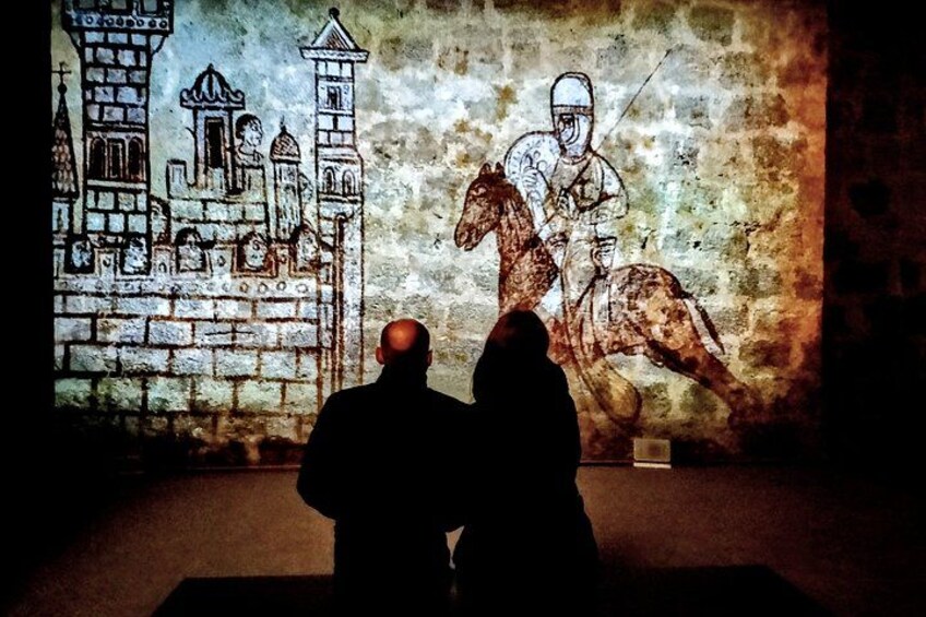 A projection of a knight on horseback on a textured wall. 4