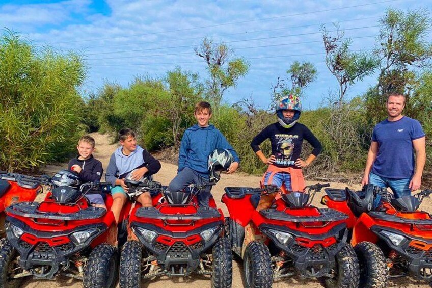 A group of people with ATVs in a desert-like environment. 3