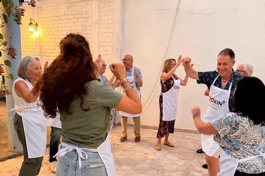 Un grupo de personas bailando en una habitación con una pared de ladrillo y una planta colgante. 2