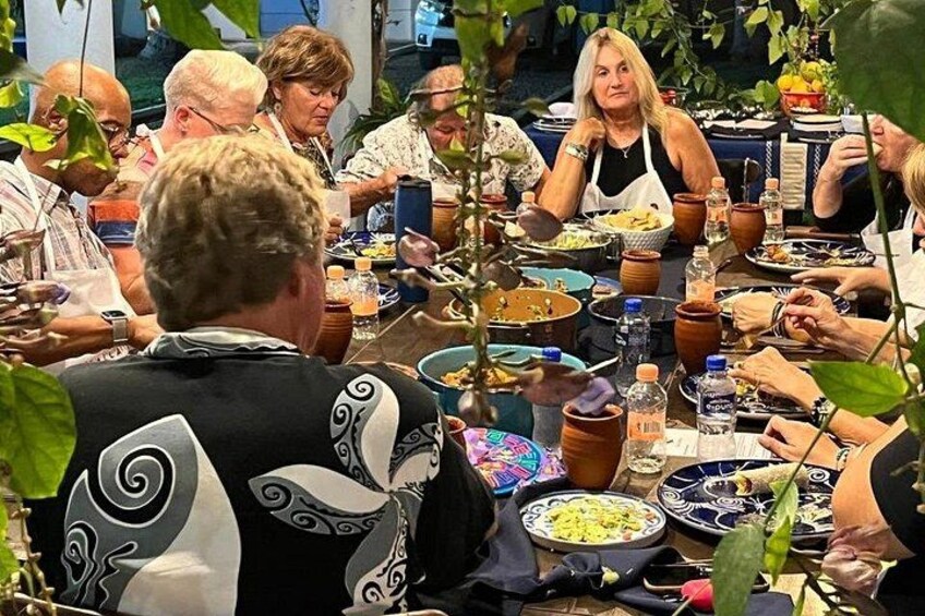 Un grupo de personas cenando en una mesa con diferentes platos y bebidas. 1