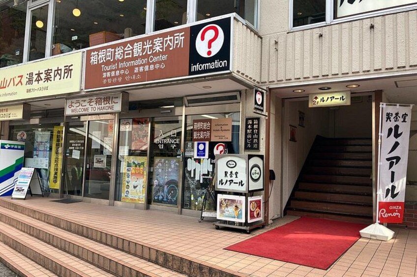 A tourist information center with signage in multiple languages, a red carpet, and a staircase leading to the entrance. 5