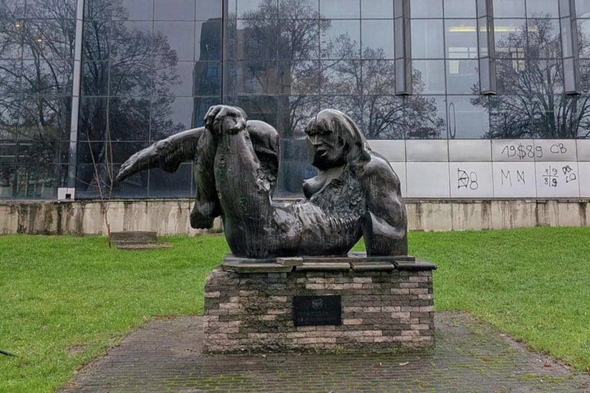 A sculpture of a person with wings in a park. 3