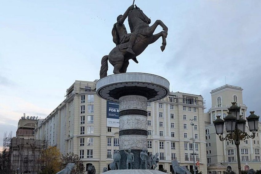 A statue of a man on a horse, a fountain, and a building with multiple windows and balconies. 2
