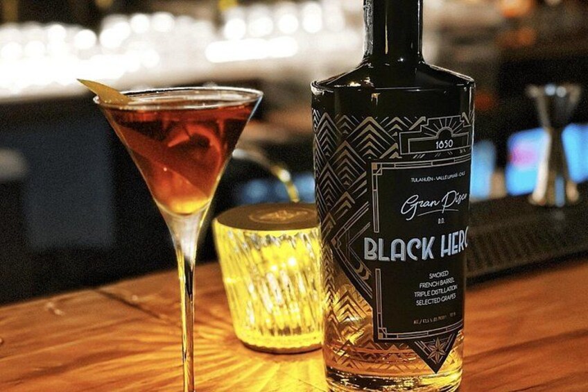 Eine Flasche Black Heron 1050 Gin und ein Martini-Glas auf einer Bar. 3