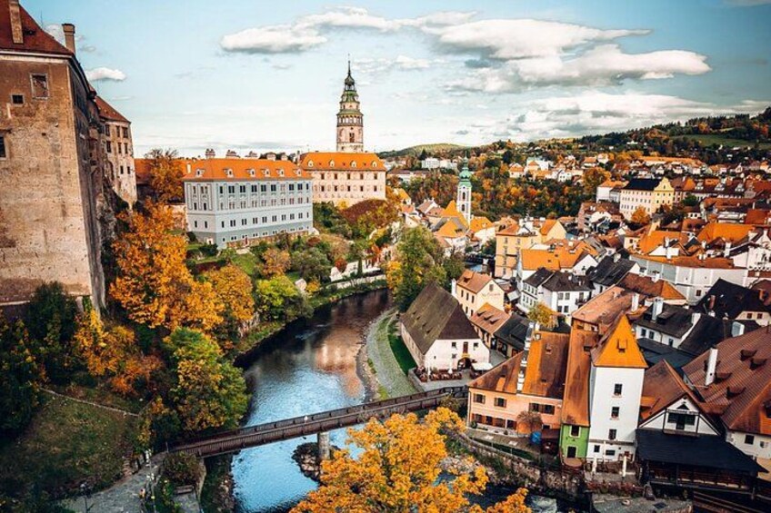 A river, a bridge, and a town with historic buildings and a prominent tower. 2