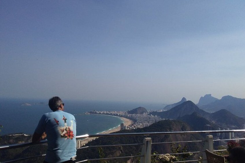 A person overlooking a coastal city with a mountain range in the background. 5