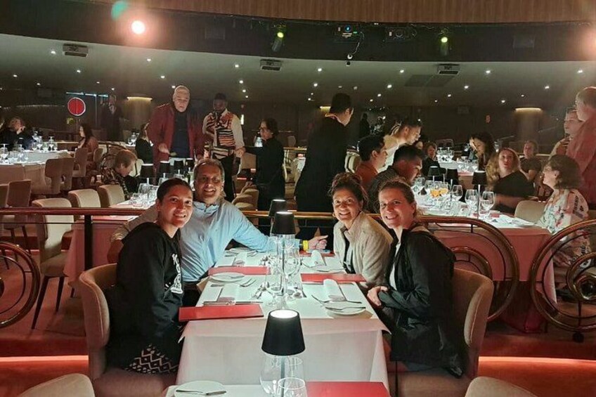 En restaurant med flere borde, gæster der spiser og personale der tager sig af serviceringen. 3