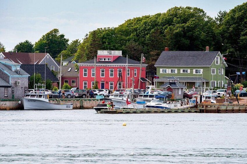 A harbor with boats, colorful houses, and a calm water body. 3
