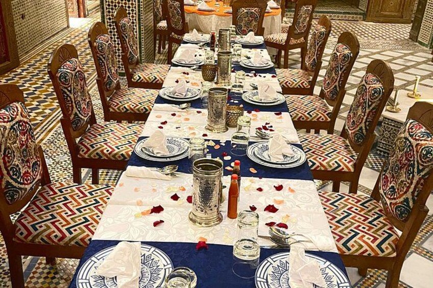 A dining table set with plates, glasses, and a candle. 2