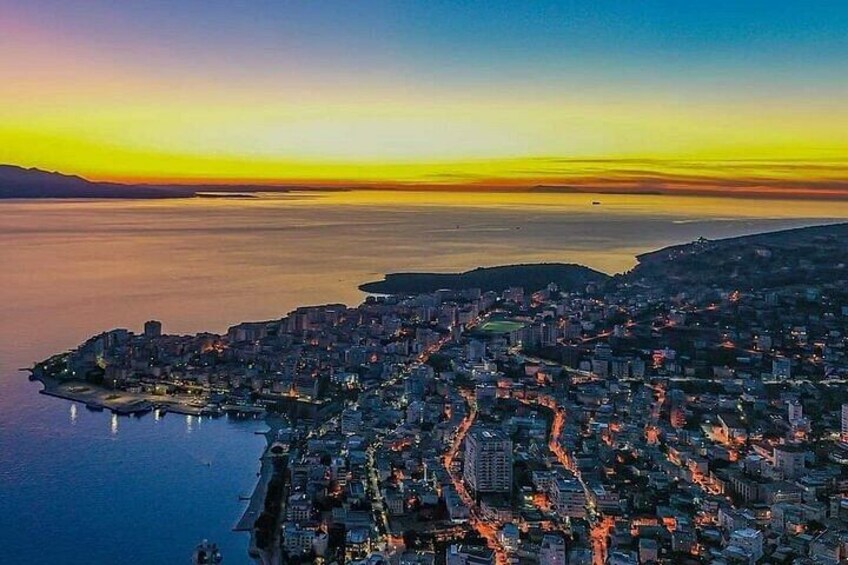 A coastal cityscape at sunset with a view of the sea and city lights. 1