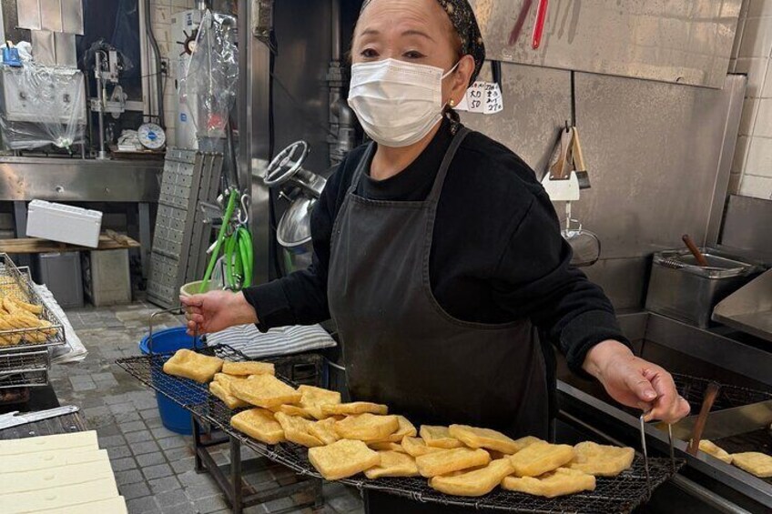 Una persona friendo comida en una cocina. 5