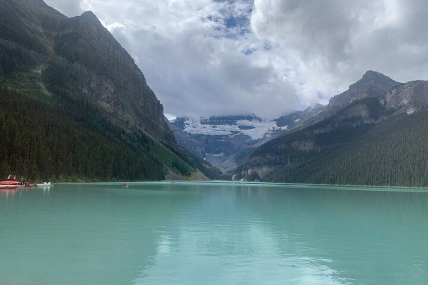 A turquoise lake surrounded by forested mountains. 3