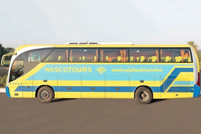 Un autobús amarillo y azul con la leyenda 'NASCOTOURS' escrito en la carrocería, estacionado en una calle. 2