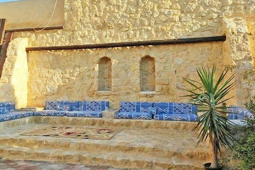 Un bâtiment en pierre avec des marches à motifs bleus et un palmier. 2