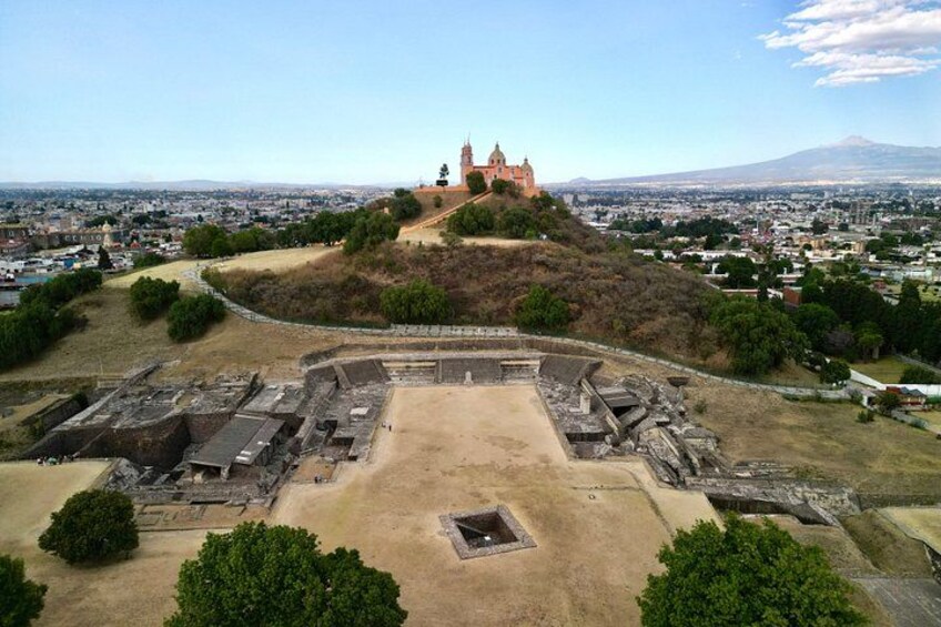 An ancient archaeological site with ruins and a castle on a hill. 2