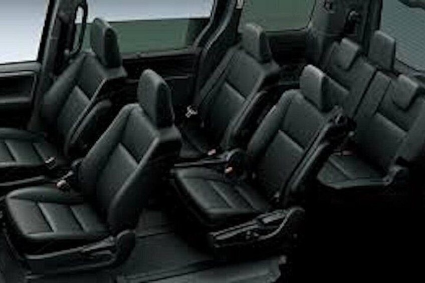 A vehicle interior with black seats and a steering wheel. 4