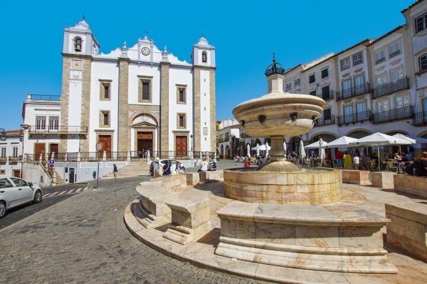 Una iglesia histórica con una fuente en el centro de una plaza. 1