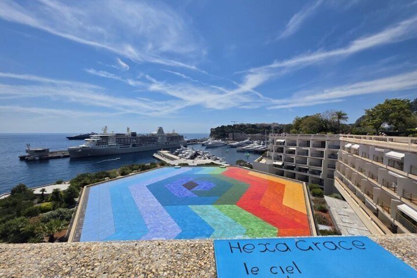 Une mosaïque colorée sur un toit, un navire de croisière amarré dans un port et un immeuble doté de balcons. 3