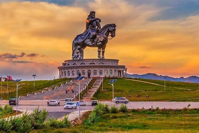 A statue of a person on horseback on a pedestal, surrounded by a circular building with steps leading up to it. 1
