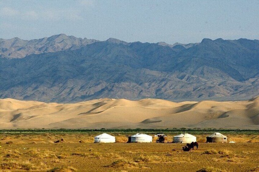A desert landscape with sand dunes and yurts. 5