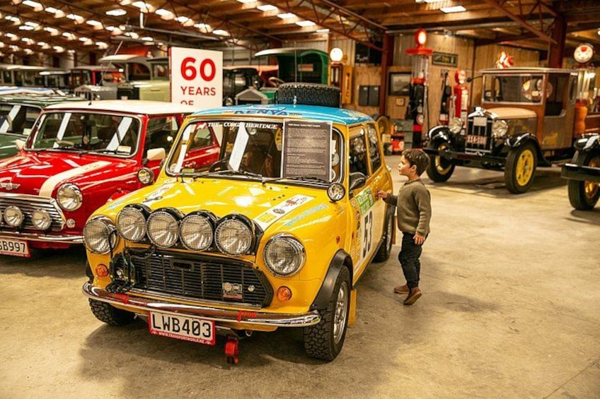 A vintage car exhibition with a yellow car prominently displayed. 4