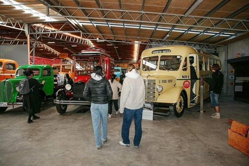 Vintage buses in a museum with visitors. 5