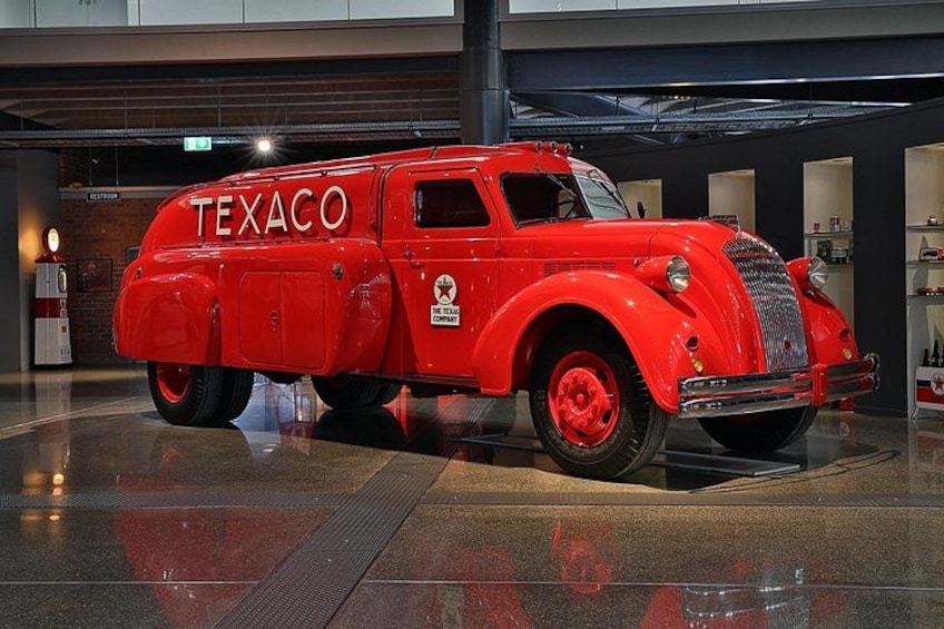 A vintage red Texaco truck in a museum setting. 1
