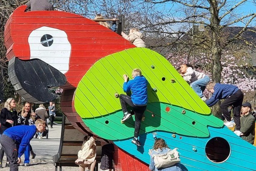 A colorful playground structure with climbing elements and a circular opening. 1