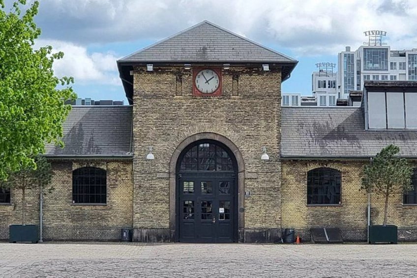 A brick building with a clock, arched door, and windows. 4