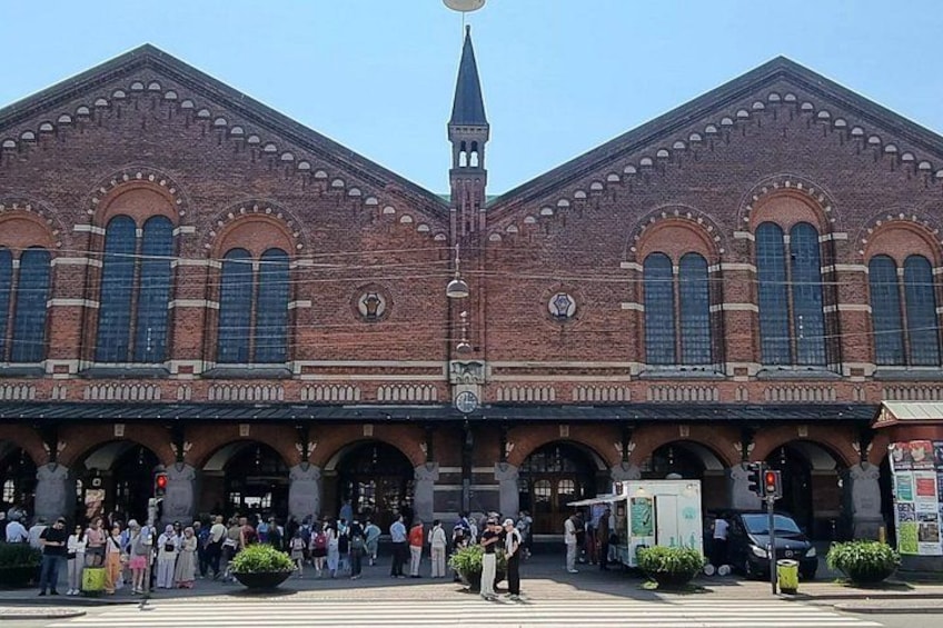 A large brick building with arched windows and a clock tower. 5