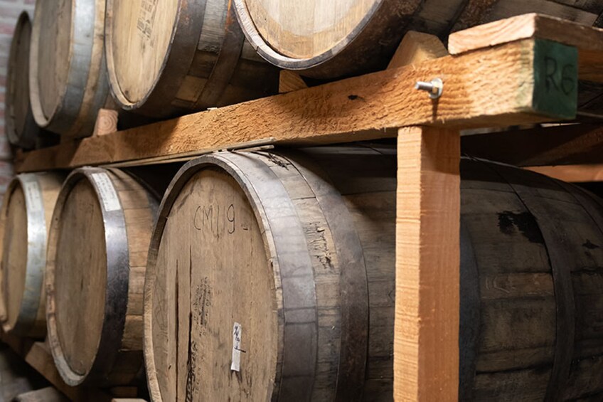 Wooden wine barrels stacked on wooden shelves. 4