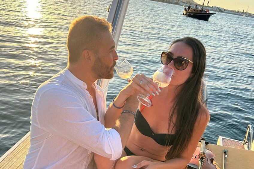 Due persone su una barca, una con un bicchiere di vino in mano. 2