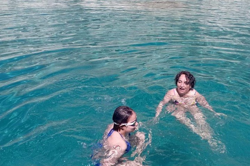 Two people swimming in clear blue water. 3