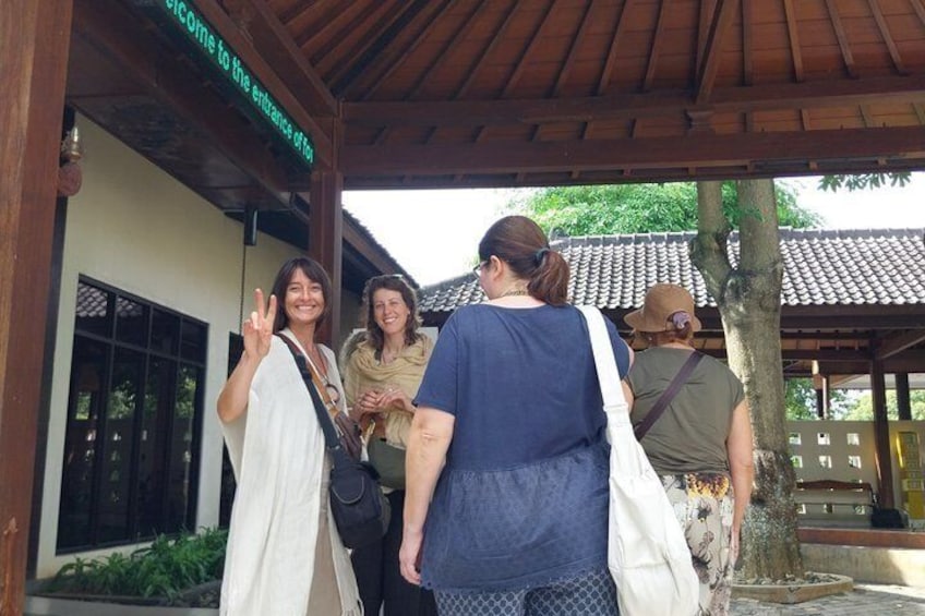A group of people standing in front of a building with a sign that reads 'Welcome to the entrance of the temple.' 5