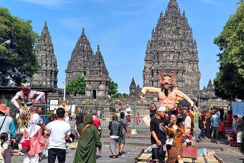 A temple complex with three large towers and a crowd of people in front. 1