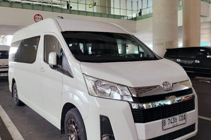 A white Toyota van with a visible license plate in a parking garage. 4