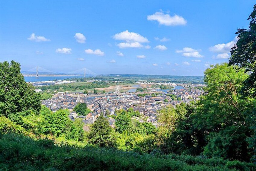 A cityscape with a bridge in the distance, surrounded by greenery. 2