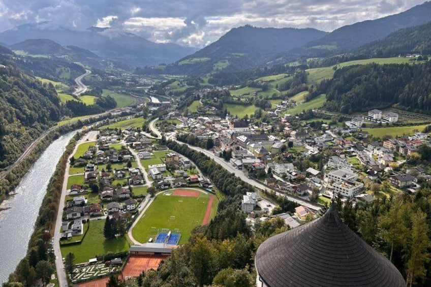 A town nestled in a valley with a river, surrounded by mountains and green fields. 5