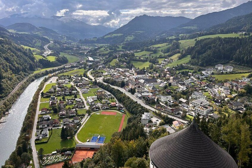 A town nestled in a valley with a river, surrounded by mountains, and featuring a sports field. 5