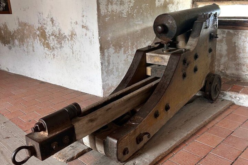 An old cannon mounted on a wooden carriage with wheels. 5