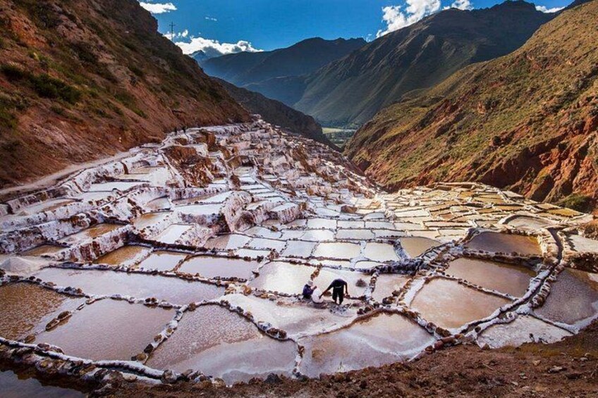 Terraced salt flats with a person standing in the foreground. 2