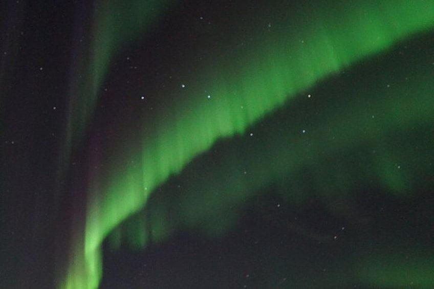 Las luces del norte (Aurora Boreal) con tonos verdes visibles y tenues puntos similares a estrellas. 4